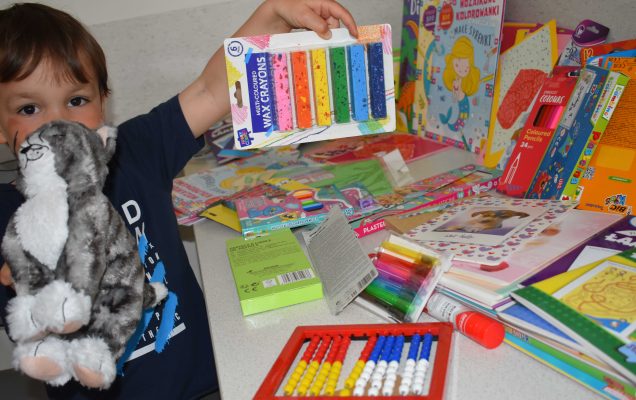 Mały pacjent z Kliniki Pediatrycznej pokazuje otrzymane prezenty