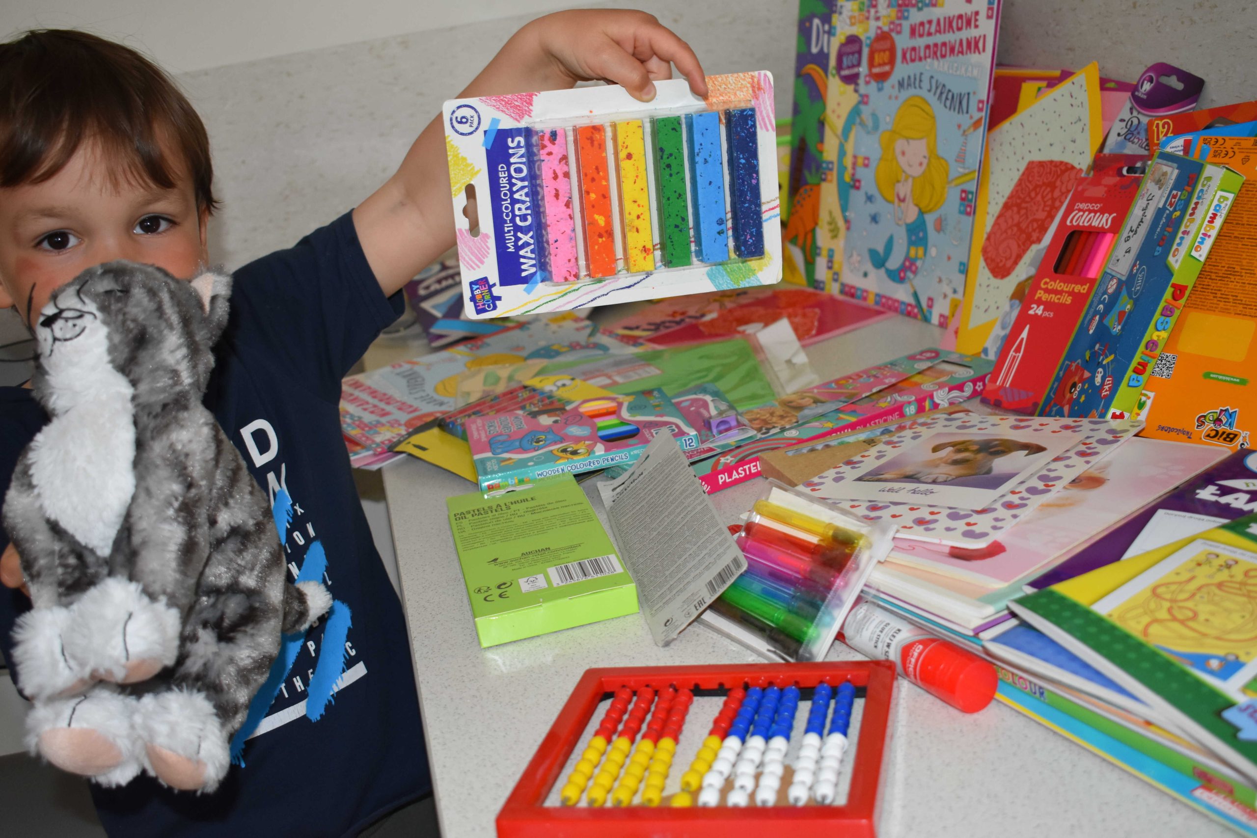 Mały pacjent z Kliniki Pediatrycznej pokazuje otrzymane prezenty
