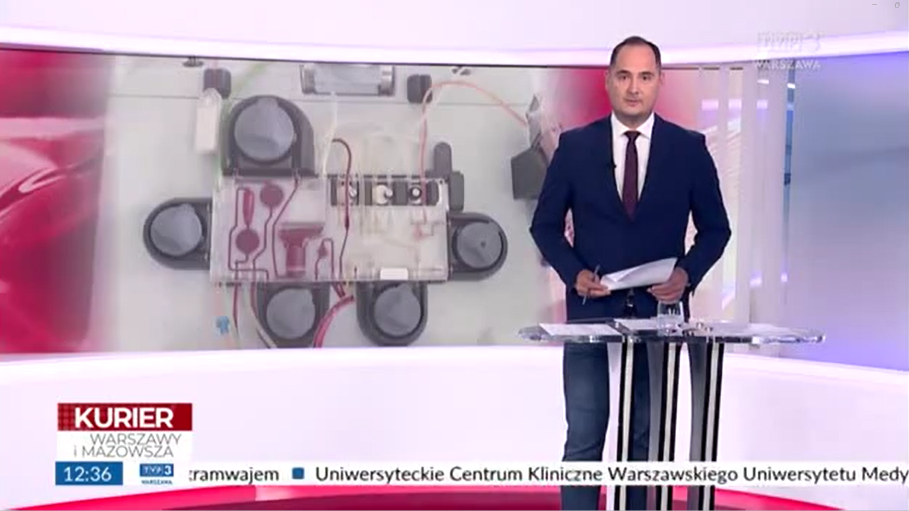 Zrzut ekrany programu telewizyjnego Kurier Warszawy i Mazowsza, N a pierwszym planie prezenter wtle studio telewizyjne