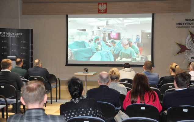 Robotic Workshop – Mastering in Deep Endometriosis w Wojskowym Instytucie Medycznym w Warszawie, Sala konferencyjna uczestnicy oglądają transmisję operacji z rzutnika.