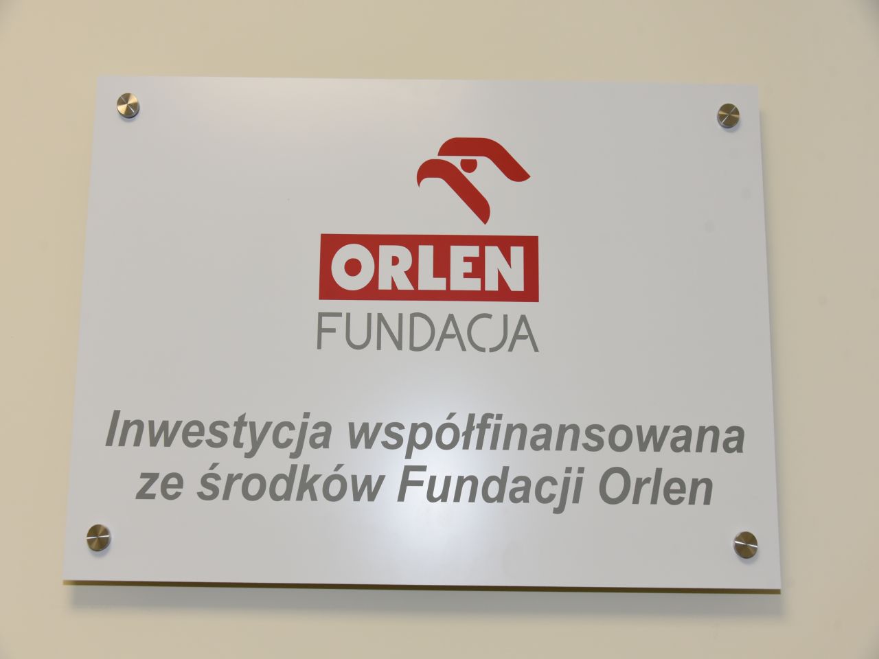 Otwarcie Budynku Rehabilitacji w WIM-PIB w Legionowie. Tablica Inwestora ORLEN. Na tablicy napis