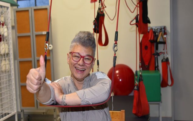 Otwarcie Budynku Rehabilitacji w WIM-PIB w Legionowie. Uśmiechnięta pacjentka podczas zabiegu rehabilitacyjnego pokazuje kciuk w górę.