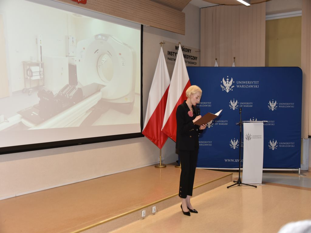 Uroczyste otwarcie Pracowni Anatomii w Wojskowym Instytucie Medycznym. Prelegentka opowiada o nowej pracowni, za nią slajd ze sprzętem medycznym.