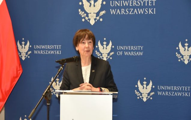 Uroczyste otwarcie Pracowni Anatomii w Wojskowym Instytucie Medycznym. Prelegentka przy mównicy, za nią logo Uniwersytetu Warszawskiego.