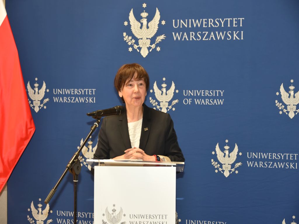 Uroczyste otwarcie Pracowni Anatomii w Wojskowym Instytucie Medycznym. Prelegentka przy mównicy, za nią logo Uniwersytetu Warszawskiego.