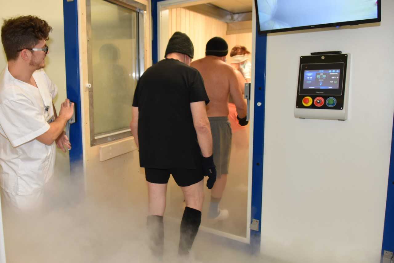 Kriokomora w Szpitalu w Legionowie. Pracownik szpitala otwiera drzwi do kriokomory mężczyznom wchodzącym na zabieg do kriokomory.