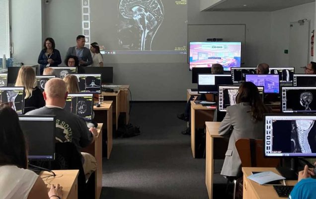 Szkolenie dla neurologów z zasad diagnostyki i leczenia stwardnienia rozsianego w wojskowym instytucie medycznym. Sala wykładowa a w niej siedzący przy komputerach słuchacze, przed nimi obraz z rzutnika przedstawiający obraz mózgu.