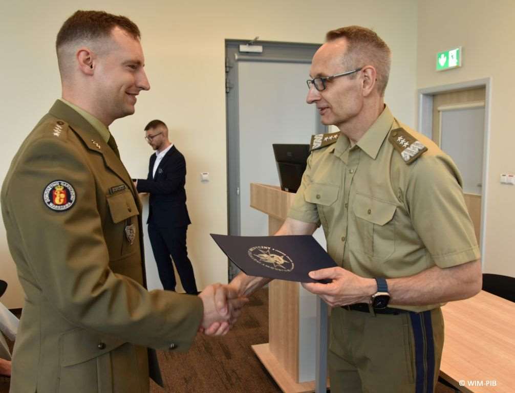 Uhonorowanie 30 absolwentów VIII edycji studiów podyplomowych w WIM-PIB, dyrektor WIM-PIB Grzegorz Gielerak wręcza dyplom absolwentowi