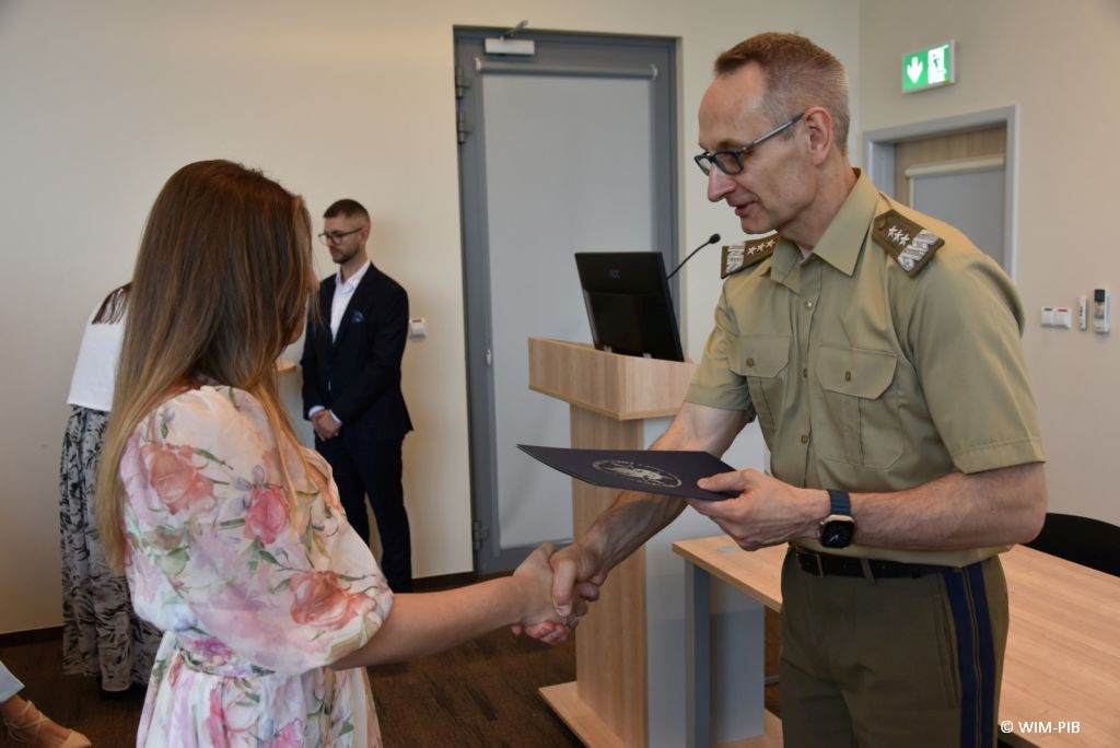 Uhonorowanie 30 absolwentów VIII edycji studiów podyplomowych w WIM-PIB, dyrektor WIM-PIB Grzegorz Gielerak wręcza dyplom absolwentowi