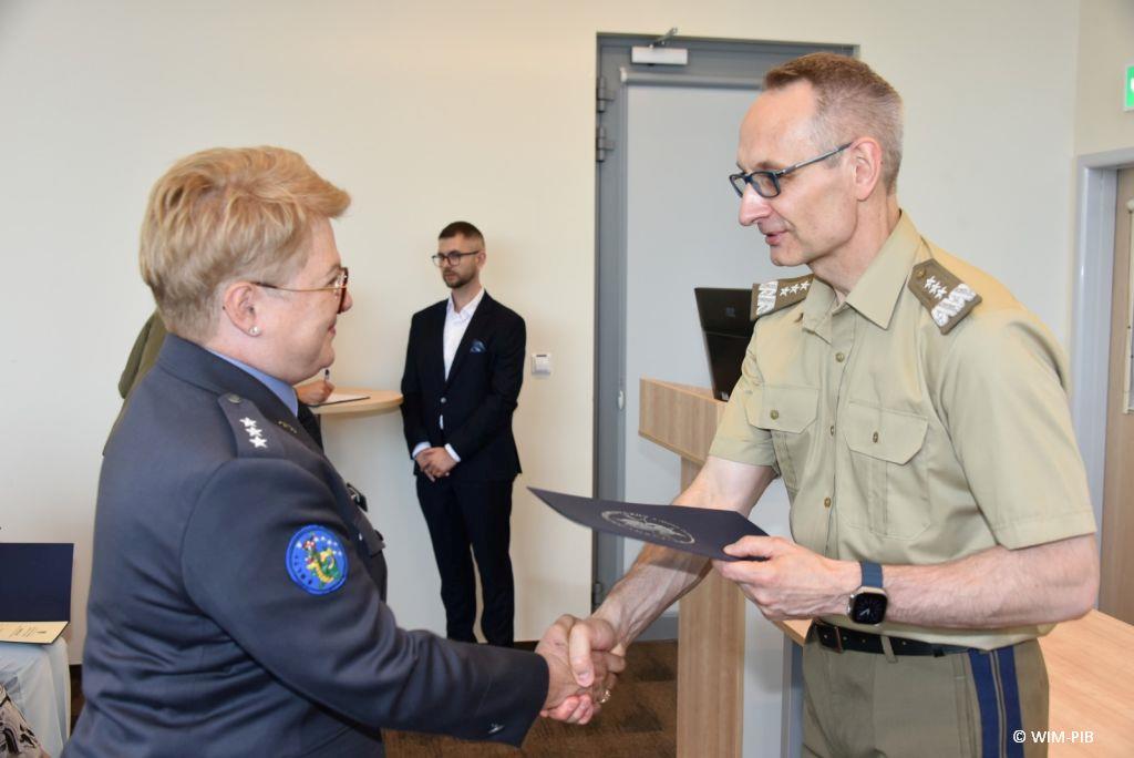 Uhonorowanie 30 absolwentów VIII edycji studiów podyplomowych w WIM-PIB, dyrektor WIM-PIB Grzegorz Gielerak wręcza dyplom absolwentowi