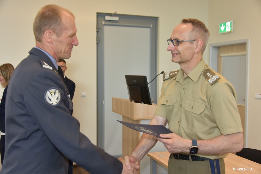 Uhonorowanie 30 absolwentów VIII edycji studiów podyplomowych w WIM-PIB, dyrektor WIM-PIB Grzegorz Gielerak wręcza dyplom absolwentowi