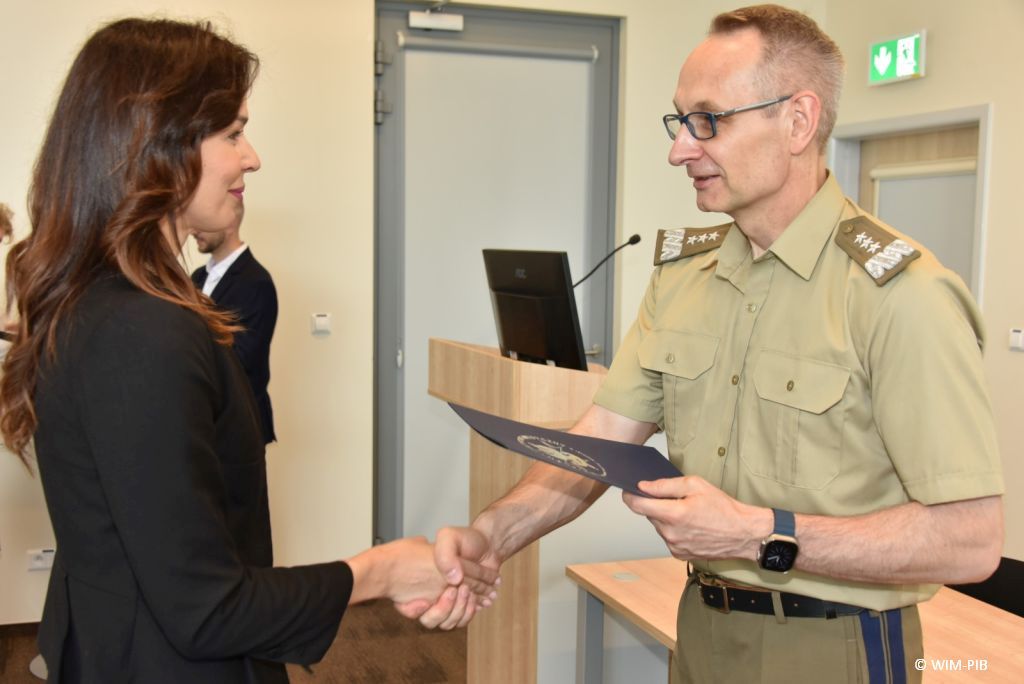 Uhonorowanie 30 absolwentów VIII edycji studiów podyplomowych w WIM-PIB, dyrektor WIM-PIB Grzegorz Gielerak wręcza dyplom absolwentowi