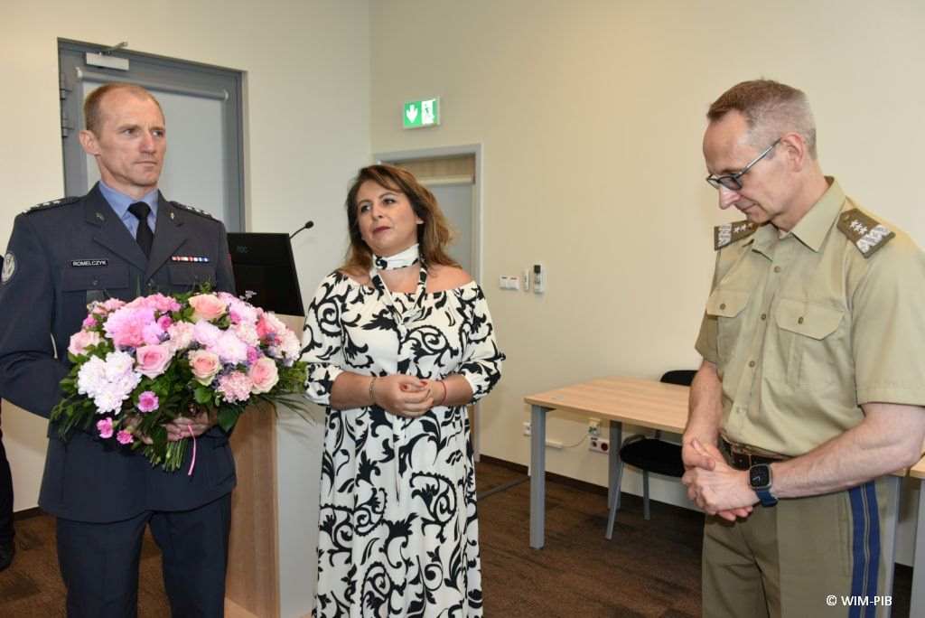 Uhonorowanie 30 absolwentów VIII edycji studiów podyplomowych w WIM-PIB, absolwenci wręczają kwiaty dyrektorowi WIM-PIB Grzegorzowi Gielerakowi
