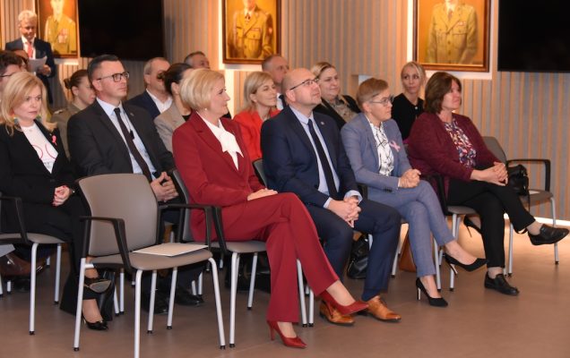 Siedzący goście na auli WIM-PIB. W pierwszym rzędzie wśród zaproszonych gości Agata KORNHAUSER-DUDA, Rzecznik Praw Pacjenta, Minister – Bartłomiej CHMIELOWIEC, Podsekretarz stanu w MNiSW Maria Mrówczyńska.