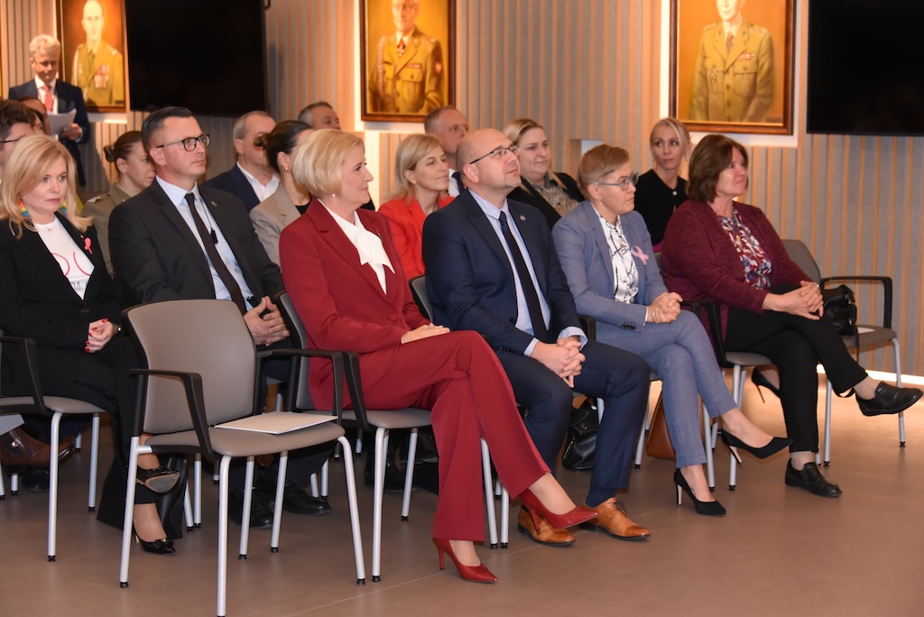 Siedzący goście na auli WIM-PIB. W pierwszym rzędzie wśród zaproszonych gości Agata KORNHAUSER-DUDA, Rzecznik Praw Pacjenta, Minister – Bartłomiej CHMIELOWIEC, Podsekretarz stanu w MNiSW Maria Mrówczyńska.
