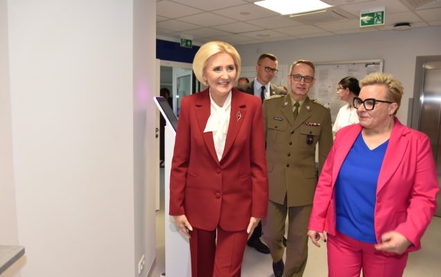 Na pierwszym planie Agata KORNHAUSER-DUDA, Lidia Wojda idą korytarzem oglądając nową Poradnię Chorób Piersi. Za nimi idzie dyrektor WIM Grzegorz Gielerak.