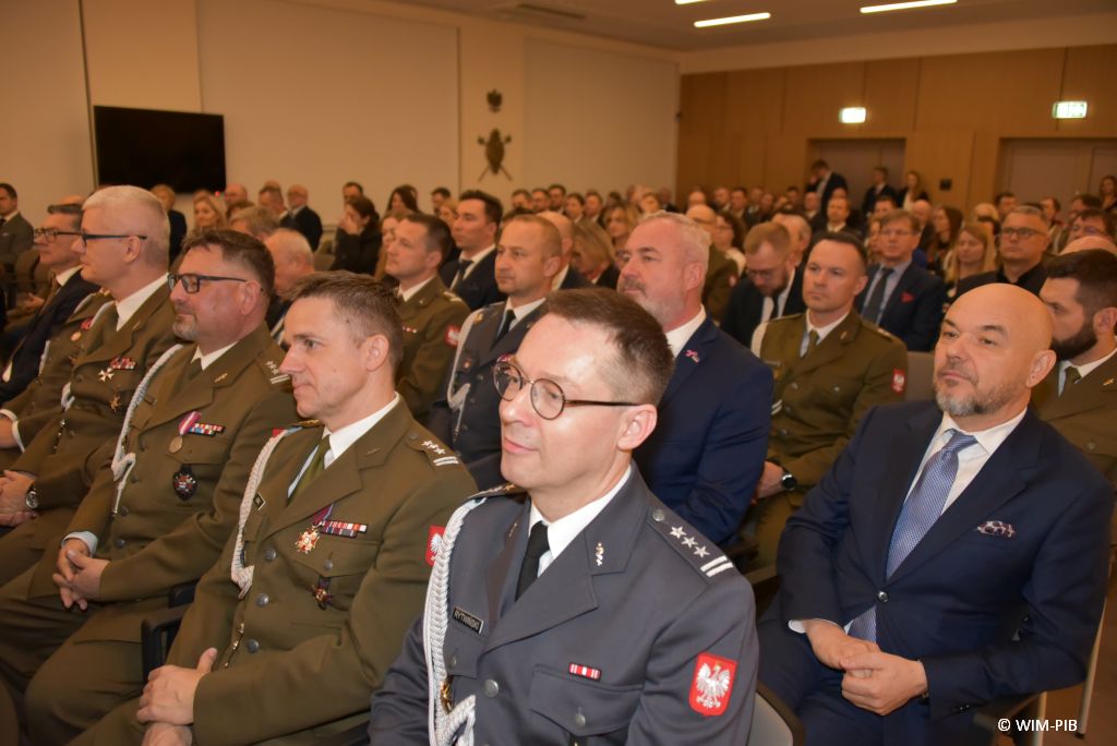 Relacja z Inauguracji Roku Akademickiego 2024/2025 w WIM-PIB. Uczestnicy inauguracji siedzą i słuchają wykładu.