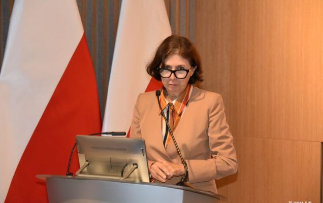 Relacja z Inauguracji Roku Akademickiego 2024/2025 w WIM-PIB. Prowadząca Inaugurację przy mównicy.