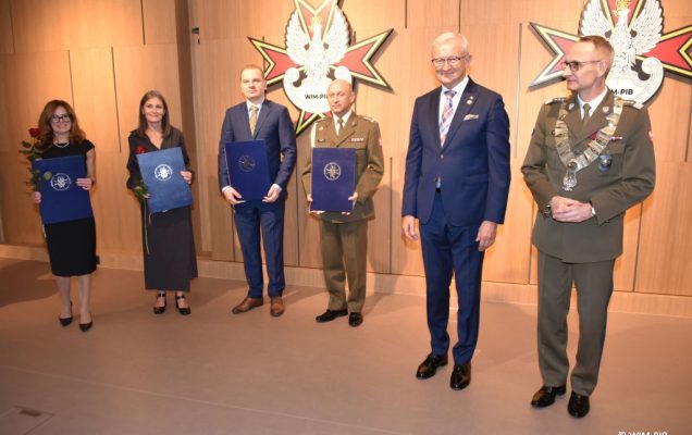 Relacja z Inauguracji Roku Akademickiego 2024/2025 w WIM-PIB. Zdjęcie grupowe doktorów habilitowanych z dyplomami, oraz z gen. broni prof. dr hab. n. med. Grzegorzem Gielerakiem.
