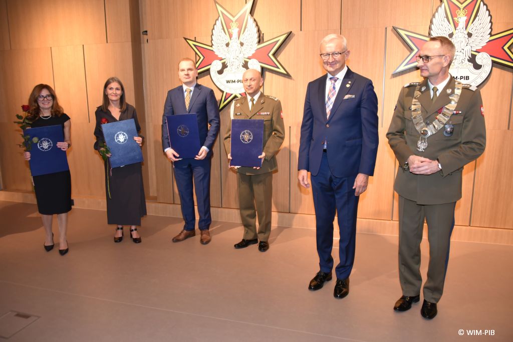 Relacja z Inauguracji Roku Akademickiego 2024/2025 w WIM-PIB. Zdjęcie grupowe doktorów habilitowanych z dyplomami, oraz z gen. broni prof. dr hab. n. med. Grzegorzem Gielerakiem.