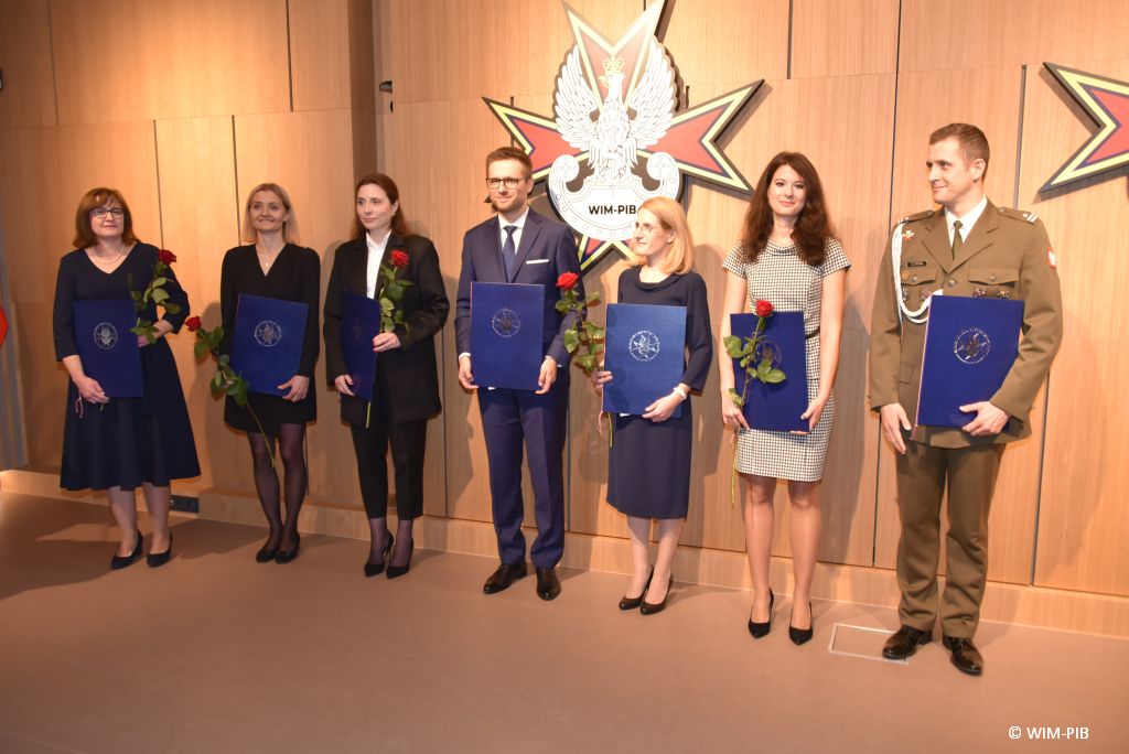 Relacja z Inauguracji Roku Akademickiego 2024/2025 w WIM-PIB. Zdjęcie grupowe doktorów z dyplomami.