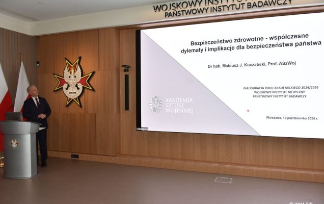Relacja z Inauguracji Roku Akademickiego 2024/2025 w WIM-PIB. Prelegent prowadzi prezentację o bezpieczeństwie zdrowotnym.