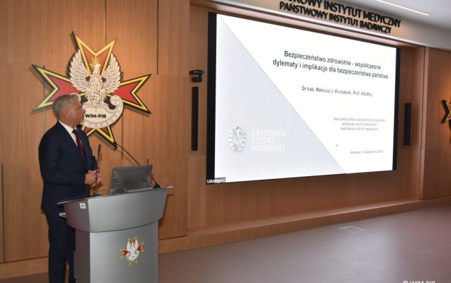 Relacja z Inauguracji Roku Akademickiego 2024/2025 w WIM-PIB. Prelegent prowadzi prezentację o bezpieczeństwie zdrowotnym.