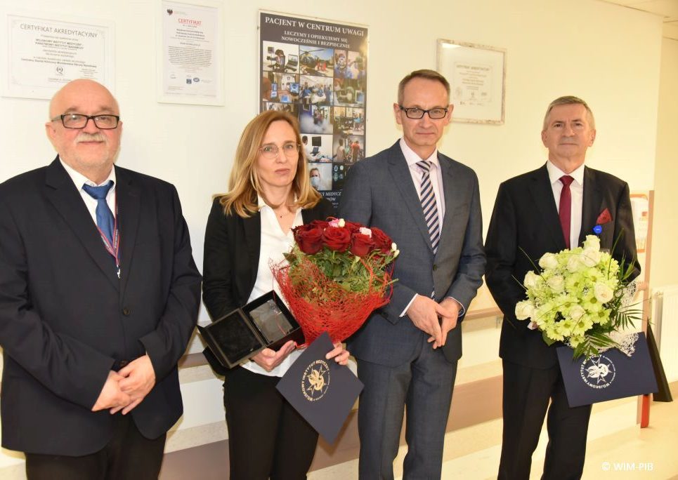 Zdjęcie grupowe. Jerzy Smoszna i Magdalena Mosakowska z wiązankami kwiatów. Obok nich Dyrektor WIM Grzegorz Gielerak.
