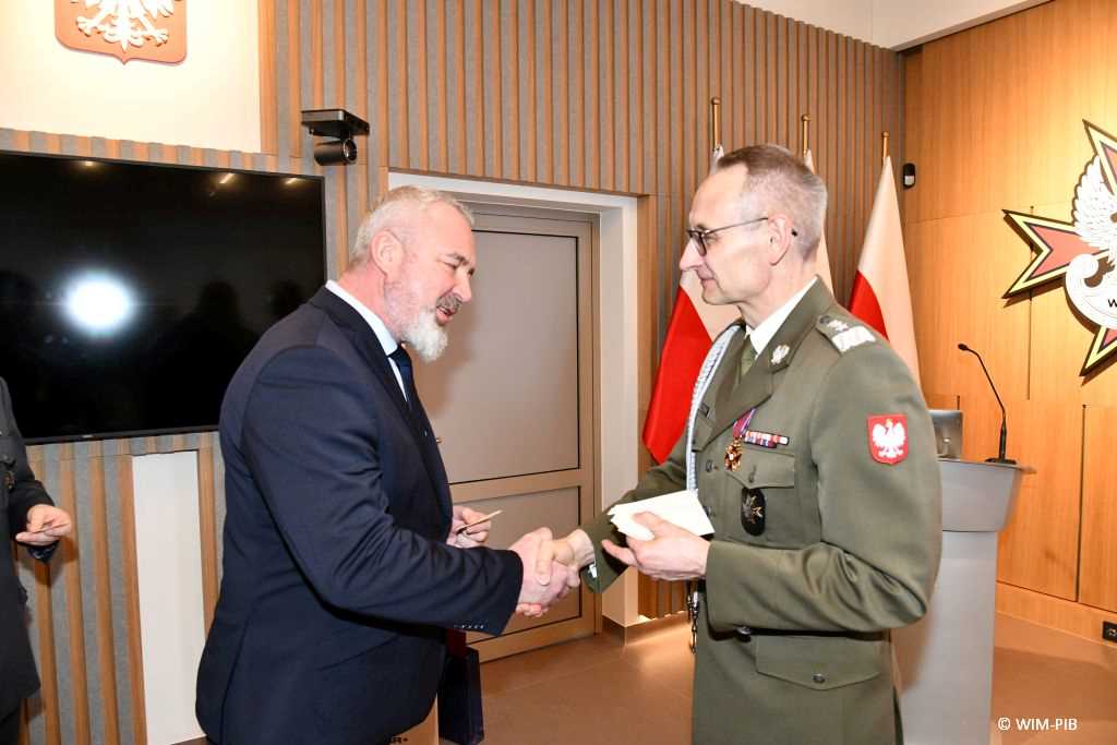 Spotkanie wigilijne w Wojskowym Instytucie Medycznym w Warszawie. Grzegorz Gielerak dzieli się opłatkiem.