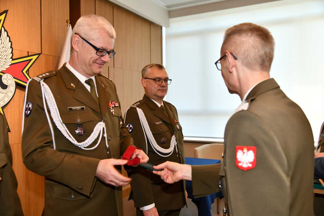 Dyrektor WIM wręcza Robertowi Ryczkowi odznaczenie.