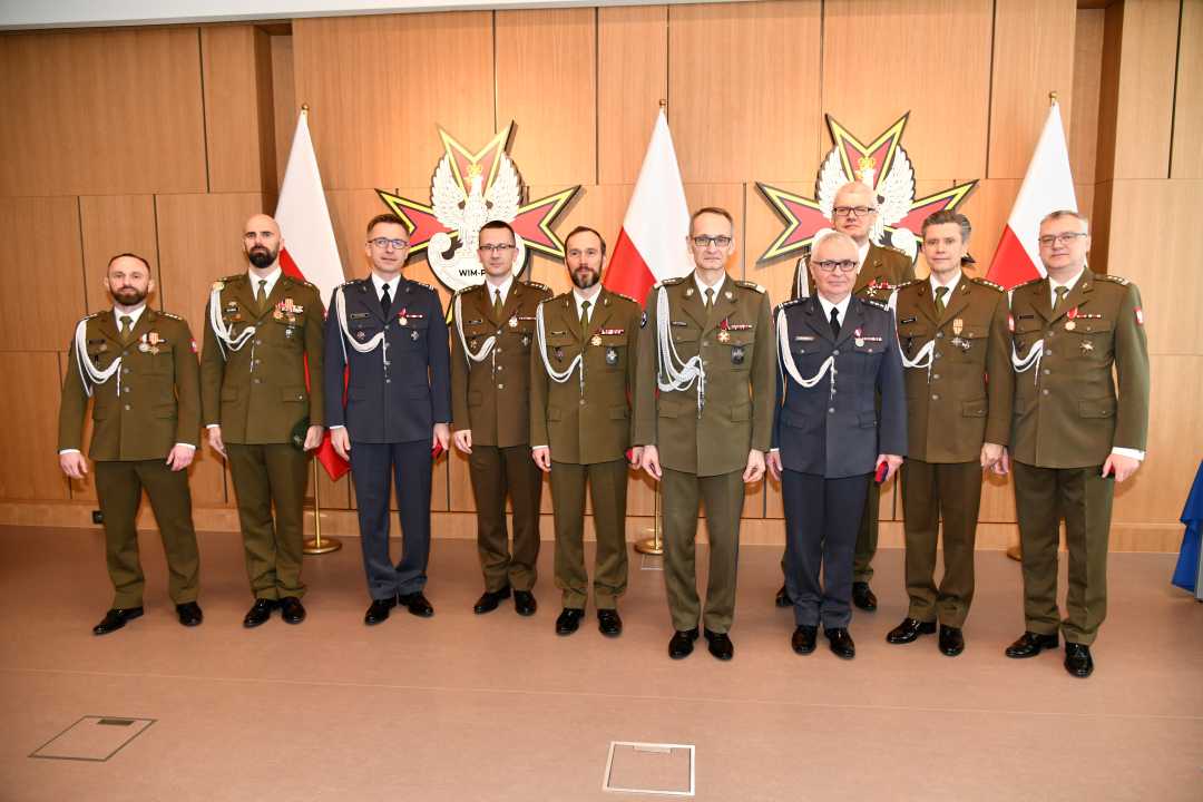 Zdjęcie grupowe. W środku dyrektor WIM Grzegorz Gielerak obok wszyscy odznaczeni pracownicy WIM.