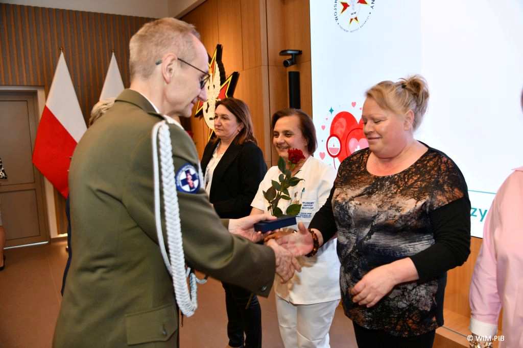 Grzegorz Gielerak wręcza odznaki pielęgniarkom.