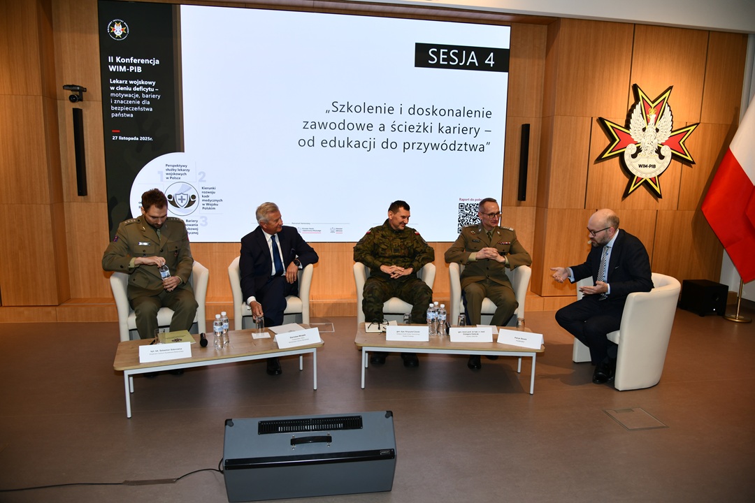 Uczestnicy siedzący w fotelach podczas panelu dyskusyjnego, za ich plecami wyświetlony fragment prezentacji.