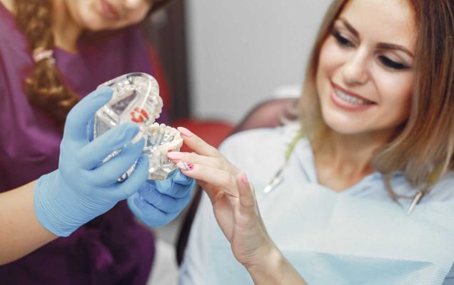 Gabinet lekarski. Dwie kobiety lekarka i pacjentka oglądają model szczęki.