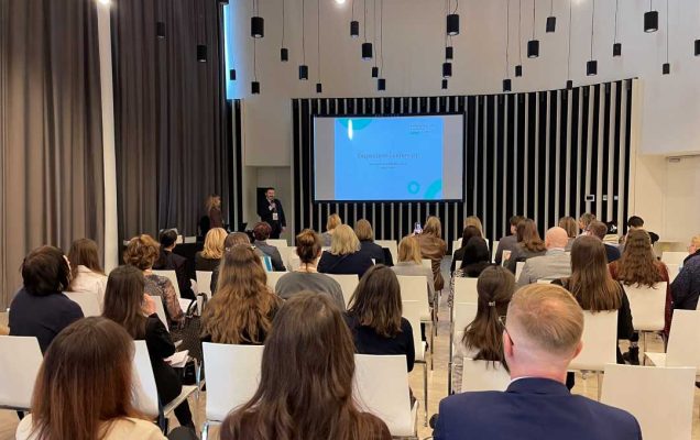 Ujęcie z tyłu sali słuchaczy podczas wykładu na sali konferencyjnej.