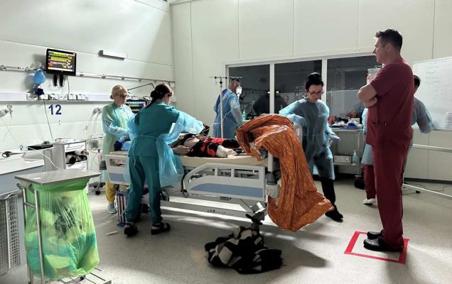 Ćwiczenia na sali medycznej w Centrum Symulacji Medycznej. Medycy nad stołem z fantomem na sali operacyjnej.