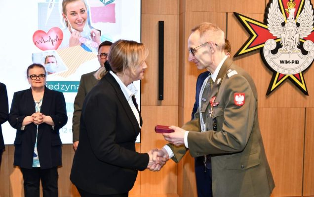 Dyrektor WIM wręcza pielęgniarce odznaczenie.