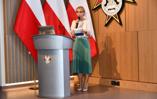 Małgorzata Złotkowska, kierownik Biura Dyrektora WIM-PIB, główny specjalista ds. komunikacji wewnętrznej prowadzi uroczystość na auli Wojskowego Instytutu Medycznego.