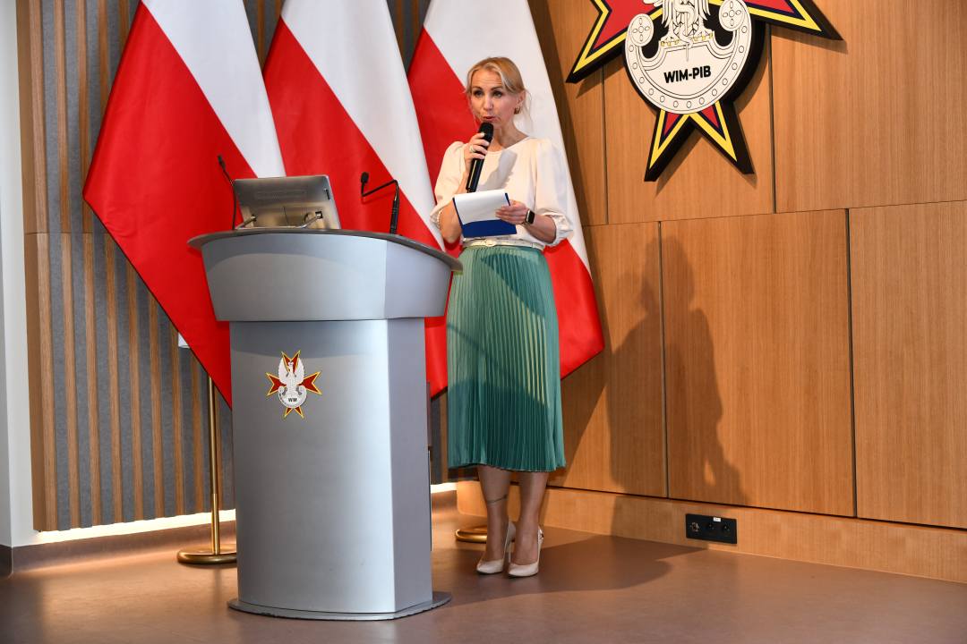 Małgorzata Złotkowska, kierownik Biura Dyrektora WIM-PIB, główny specjalista ds. komunikacji wewnętrznej prowadzi uroczystość na auli Wojskowego Instytutu Medycznego.