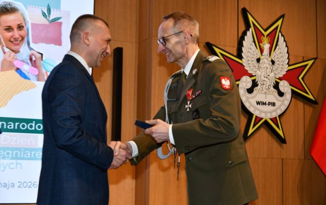 Dyrektor WIM wręcza odznaczenie pracownikowi.