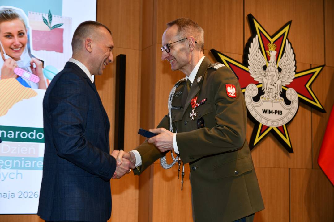 Dyrektor WIM wręcza odznaczenie pracownikowi.