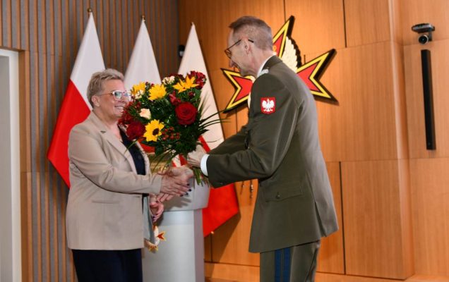 Dyrektor Wim wręcza Lidii Wojdzie bukiet kwiatów.