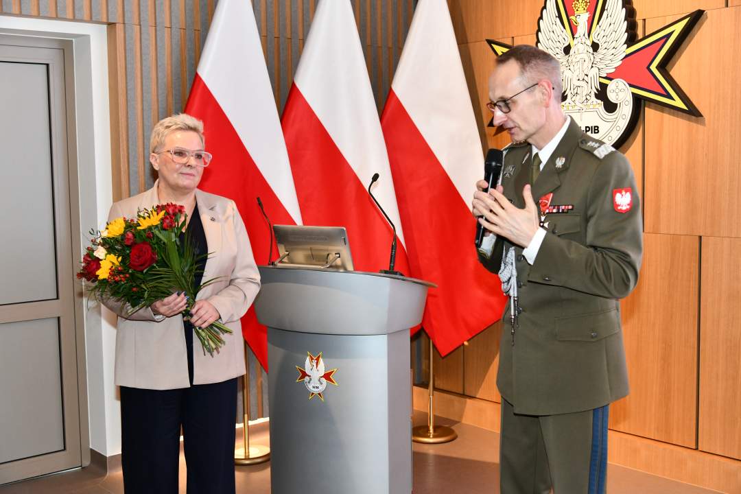 Lidja Wojda z bukietem kwiatów obok dyrektor WIM.