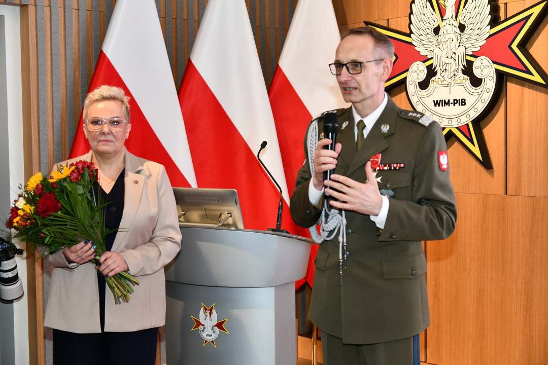Lidja Wojda z bukietem kwiatów obok dyrektor WIM.