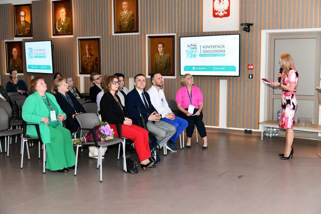 Małgorzata Złotkowska, kierownik Biura Dyrektora WIM-PIB, główny specjalista ds. komunikacji wewnętrznej prowadzi konferencję. Przed nią siedzący uczestnicy konferencji.