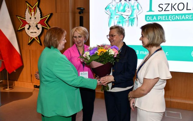 Zofia Sienkiewicz, Agata Stępniak, Lidia Wojda z bukietem kwiatów, Aneta Wilk na auli WIM.