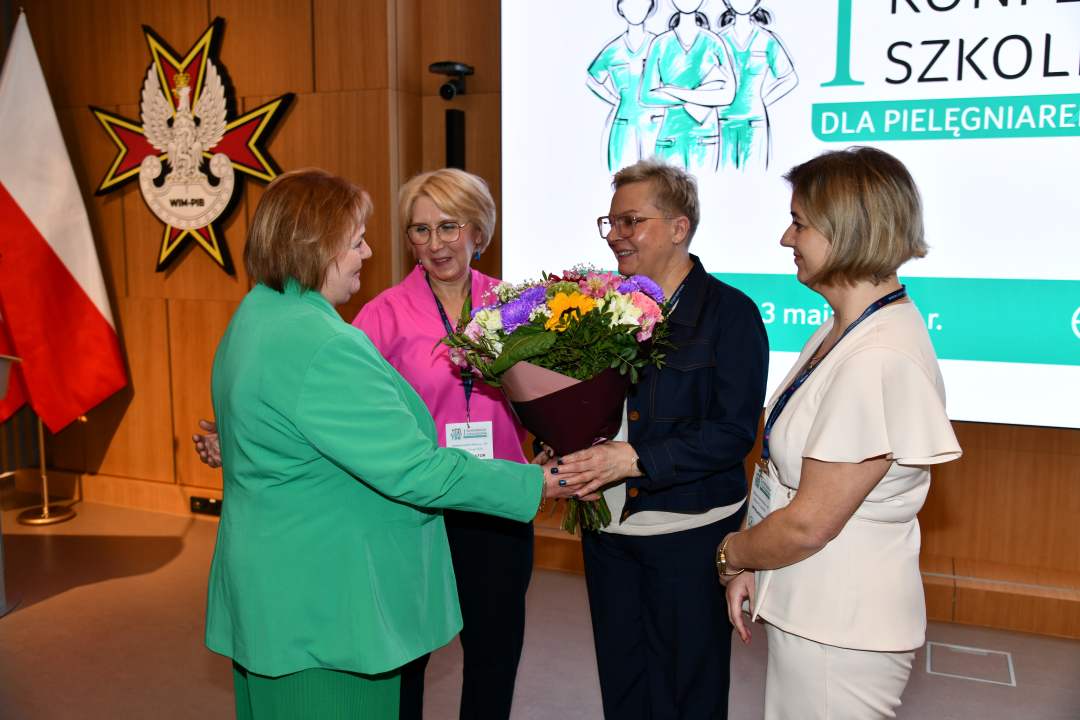 Zofia Sienkiewicz, Agata Stępniak, Lidia Wojda z bukietem kwiatów, Aneta Wilk na auli WIM.