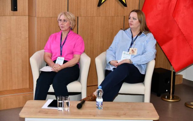 Moderatorki panelu siedzące w fotelach na auli WIM.