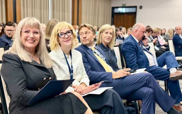 Siedzący uczestnicy na sali konferencyjnej.