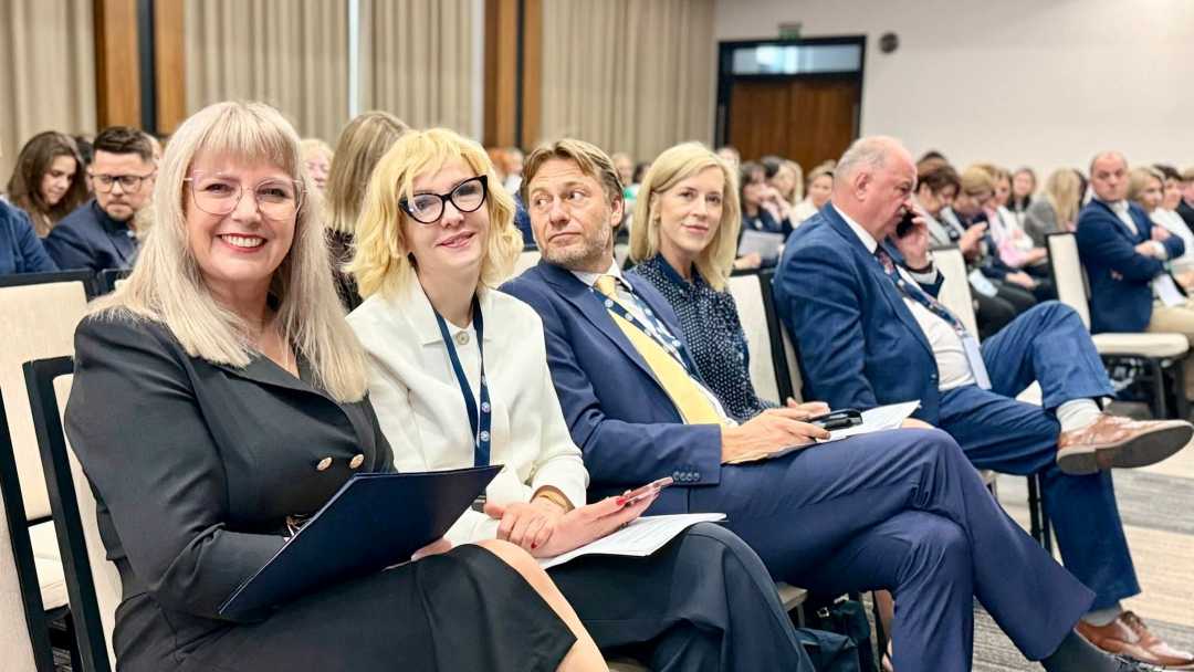 Siedzący uczestnicy na sali konferencyjnej.